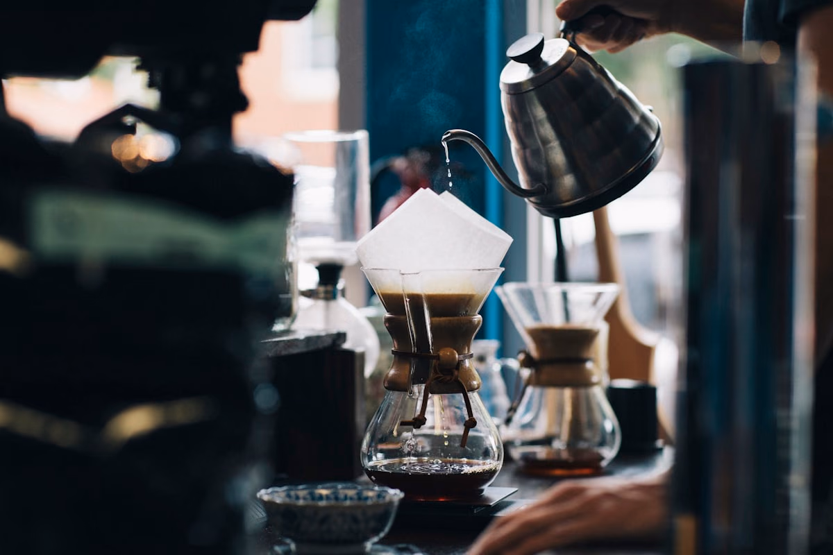 Coffee shop barista with espresso equipment and moody lighting.